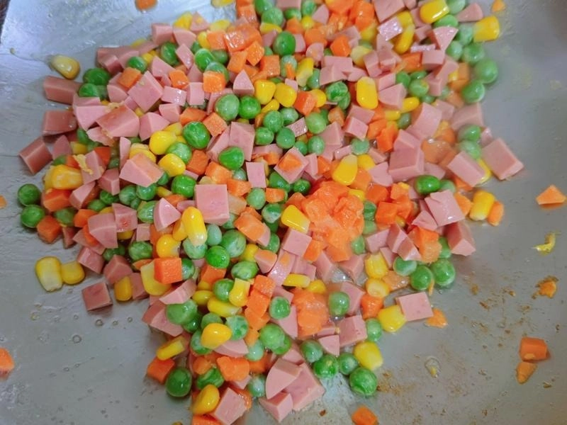 Stir-frying mixed vegetables and ham for Yangzhou Fried Rice